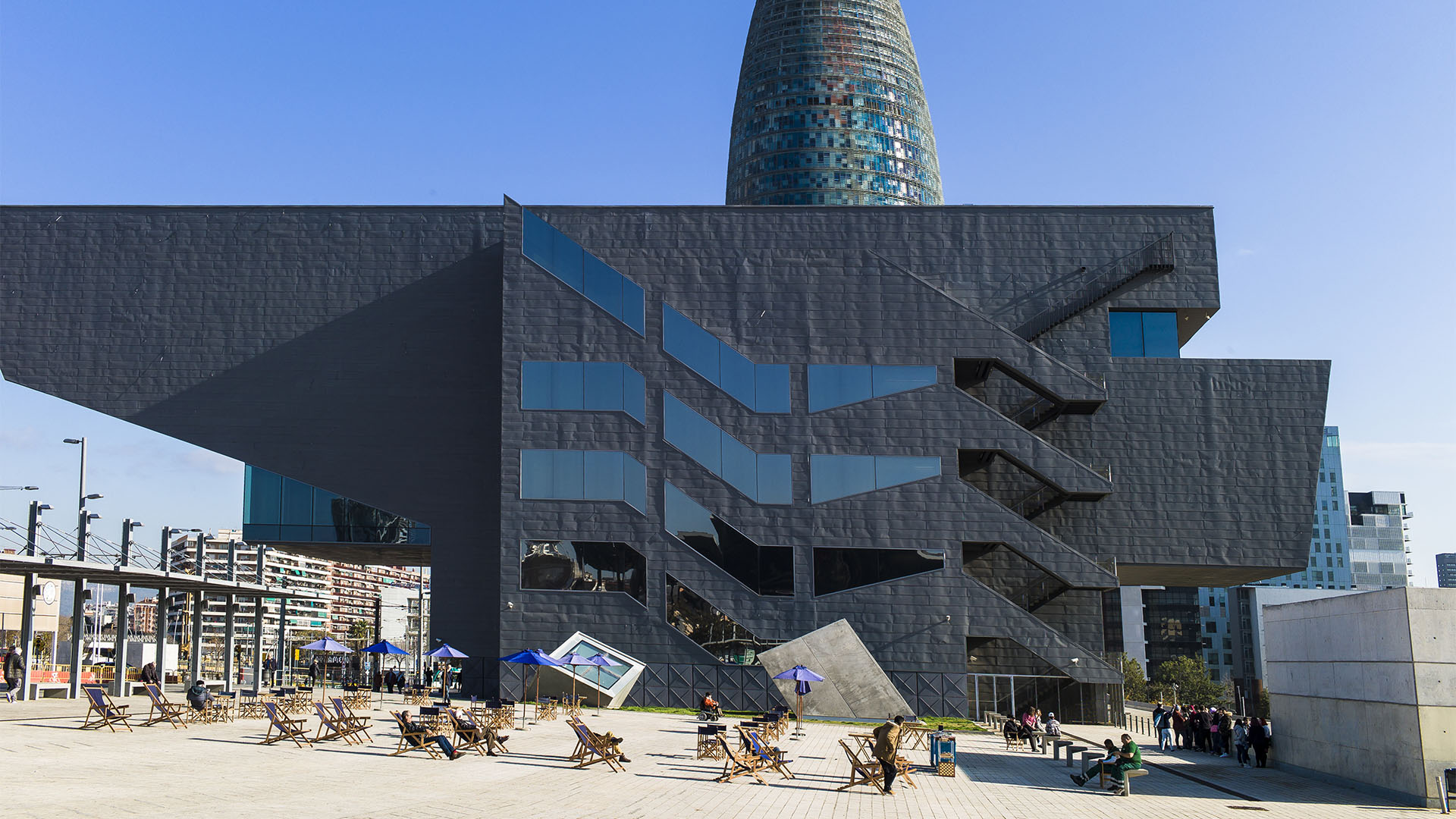 Bei sonnigem Wetter im Liegestuhl vor dem Designmuseum Barcelona entspannen. Die Stadt vermietet gegen kleinen Obulus Plätze an der Sonne. Bücher, Zeitungen, Brettspiele inkludiert.