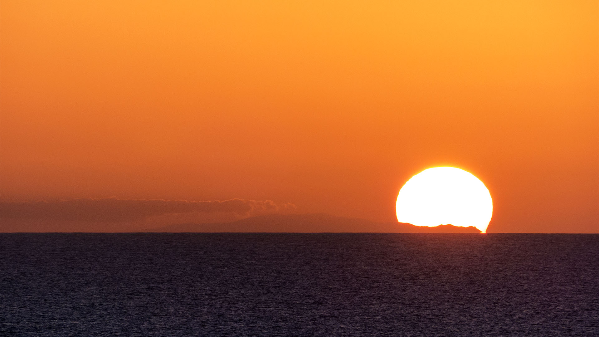 Die Silhouette von Gran Canaria in der untergehenden Sonne. Zu sehen von Fuerteventura, im Winter, wenn die Sonne weit im Süden steht.