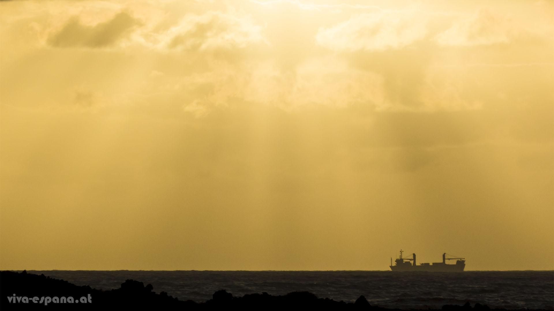 Ein Schiff taucht am Horizont auf und zieht filmreif vorbei.