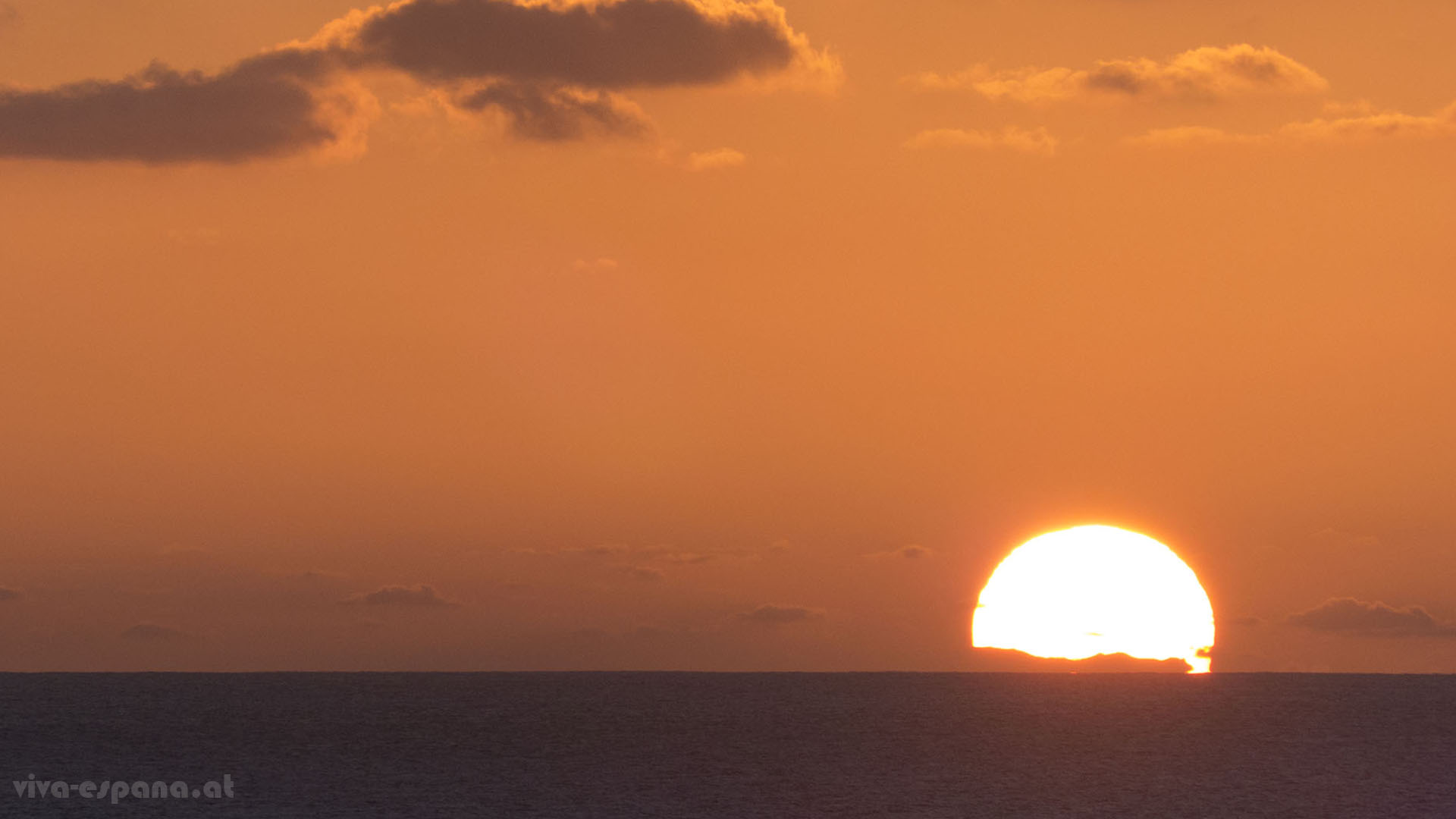 Weihnachten, die Sonne weit im Süden. Die Silhouette Gran Canarias taucht in der untergehenden Sonne auf.