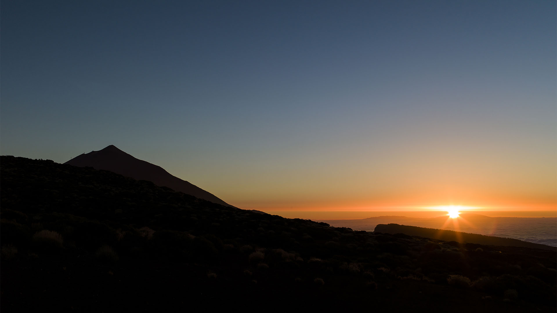 Der Pico del Teide (3.718 m) auf Teneriffa ragt bei Sonnenuntergang aus dem Wolkenmeer.